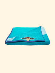 Model “Swell” of Tucca beach towel folded while showing its zipper closure waterproof hidden pocket, that can be used to store your phone or other belongings as well as to keep your Tucca pins as the pictures shows. The ones that can be used to fix your beach towel to the sand.