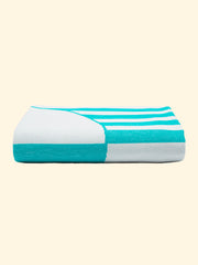 Modèle "Mayeri" de Tucca légère serviette de plage 100% coton biologique, parfaitement plié comme présenté sur l'emballage. Montrant que c'est une serviette de plage très chose facile à transporter.